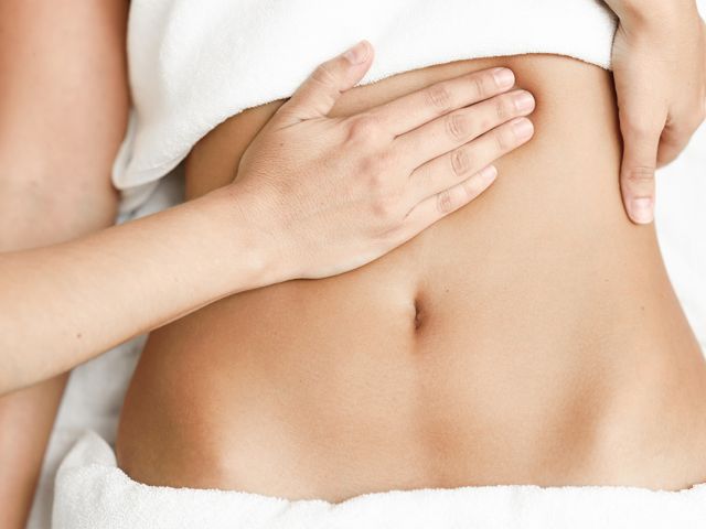 Hands massaging female abdomen.Therapist applying pressure on belly.