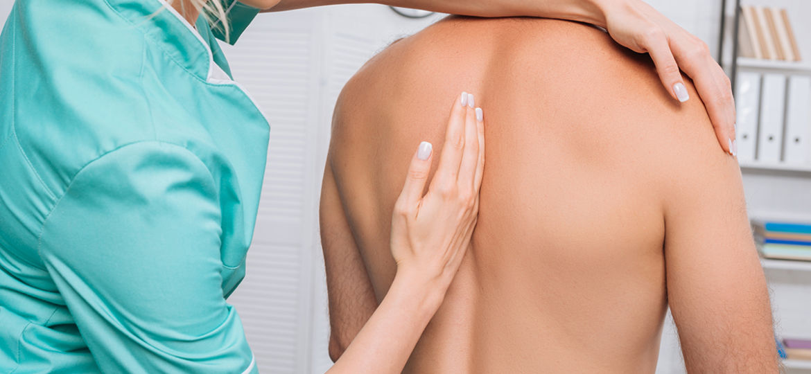 back view of man having chiropractic adjustment in clinic