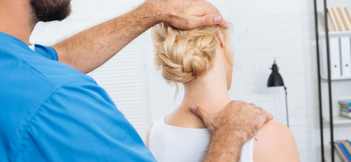 partial view of chiropractor stretching neck of woman during app